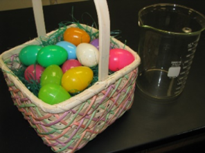Colourful plastic Easter eggs in a basket next to a beaker.