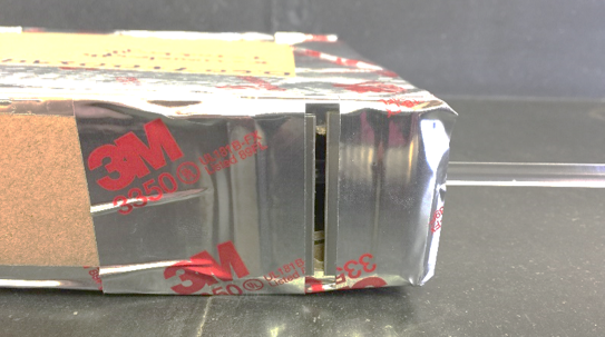 Foil covered box with slit in side.