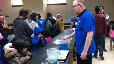 Serghei Bocaniov demonstrates an experiment to children and parents during the busy Science Open House.