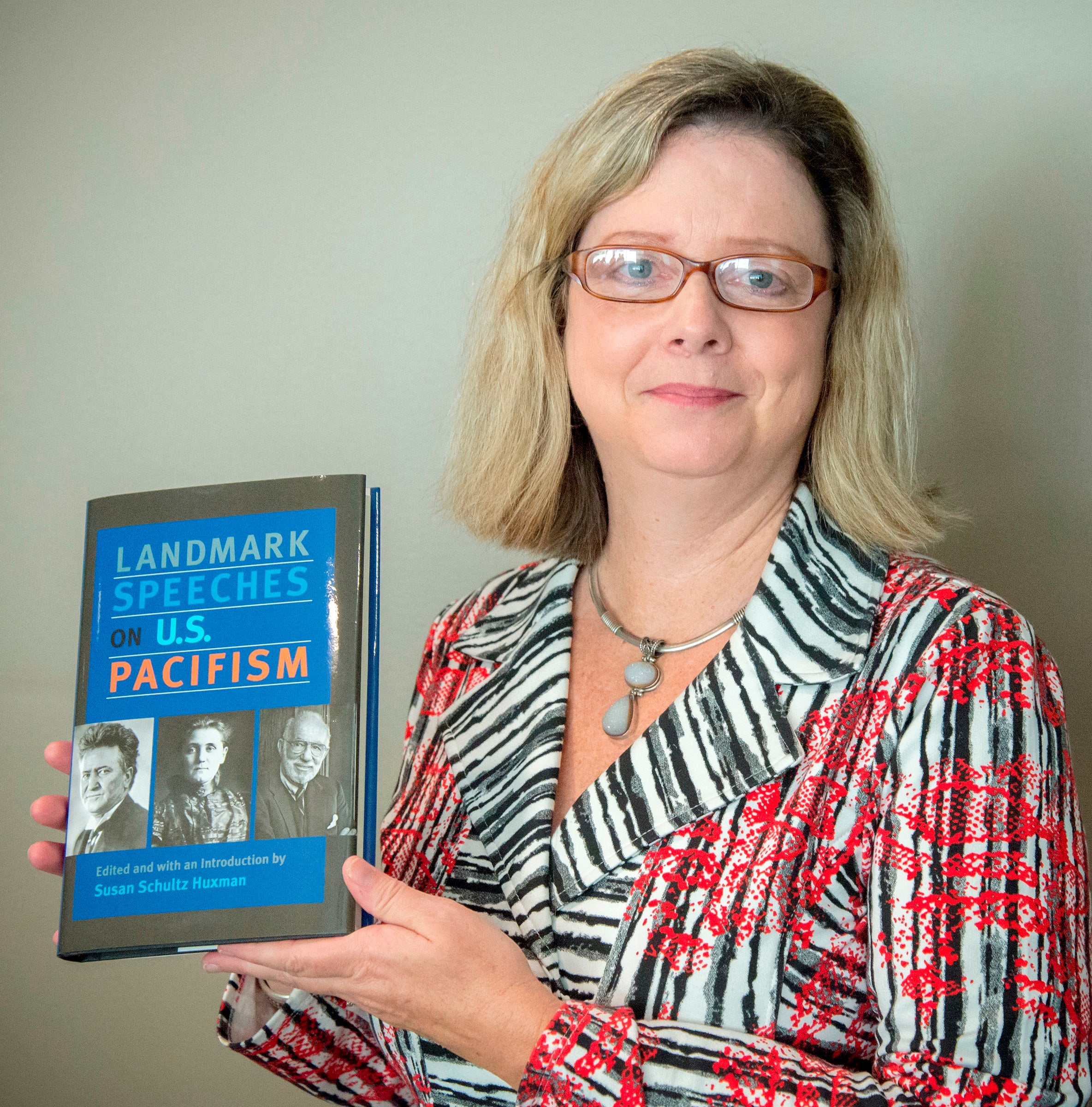 Susan Huxman holding her new book