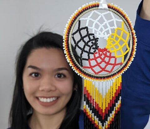 A woman holding an Indigenous craft