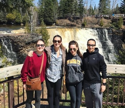 A group standing in front of a waterfall