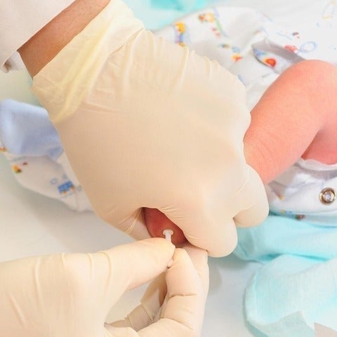 gloved hands stabilising blood sugar of baby