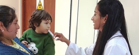 Co-op student giving child medication orally.