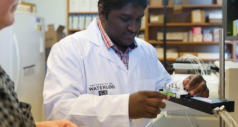 Graduate student Lokesh in the lab preparing research equipment.