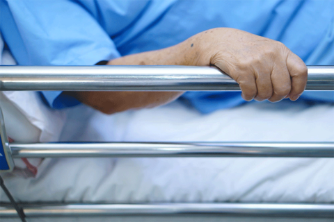 Person holding hospital bed rail