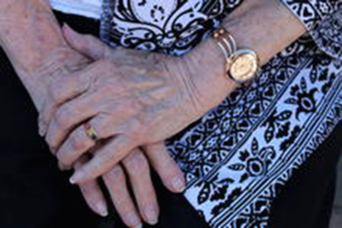 Older person holding their hands together