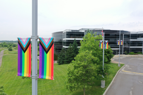 View of exterior of OpenText office building with LGBTQ+ pride flags