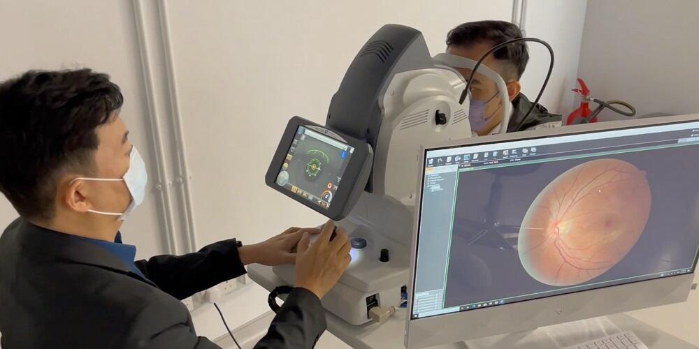 A vision scientist looking at a retinal scan on a computer screen